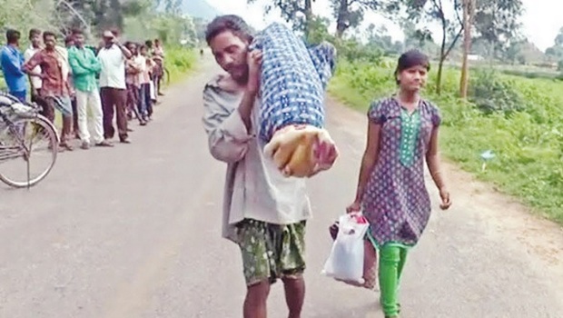 Indian tribal man walks 10 km to his village carrying his dead wife's body on his shoulders as neither the government hospital or any one else would give him a vehicle to carry the body.    