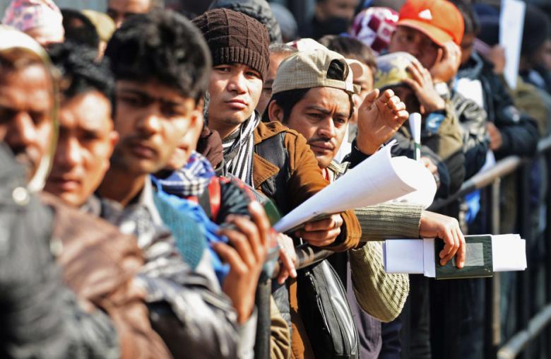 Nepalese manual laborers queue up at a work place in the Middle East 