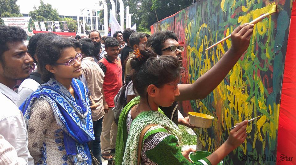 Protestors against the environmentally destructive Indo-Bangla power plant in the Sundarbans paint the walls of Dhaka's Shaheed Minar. 