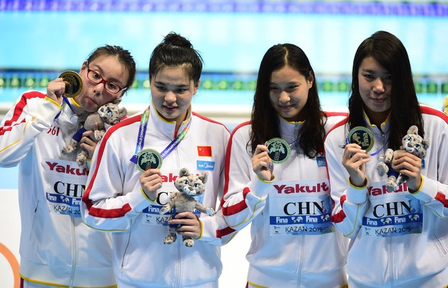 Team China celebrates its gold medal during the podium ceremony for the women's 4x100m medley relay swimming event at the 2015 FINA World Championships in Kazan on August 9, 2015. Shi Jinglin, Lu Ying, Fu YuanHui and Shen Duo competed in the event.  AFP PHOTO / ALEXANDER NEMENOV        (Photo credit should read ALEXANDER NEMENOV/AFP/Getty Images)
