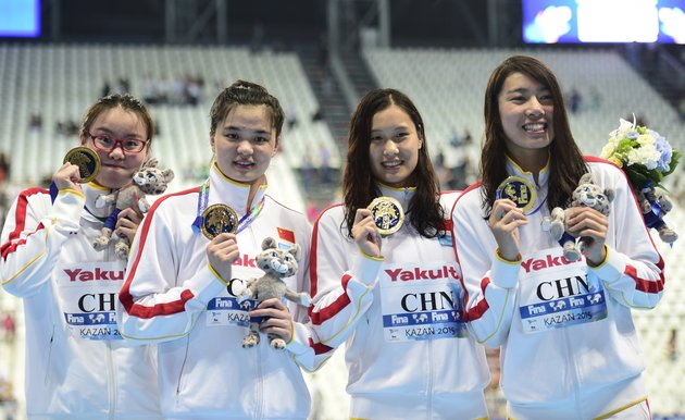 Team China celebrates its gold medal during the podium ceremony for the women's 4x100m medley relay swimming event at the 2015 FINA World Championships in Kazan on August 9, 2015. Shi Jinglin, Lu Ying, Fu YuanHui and Shen Duo competed in the event. AFP PHOTO / MARTIN BUREAU        (Photo credit should read MARTIN BUREAU/AFP/Getty Images)