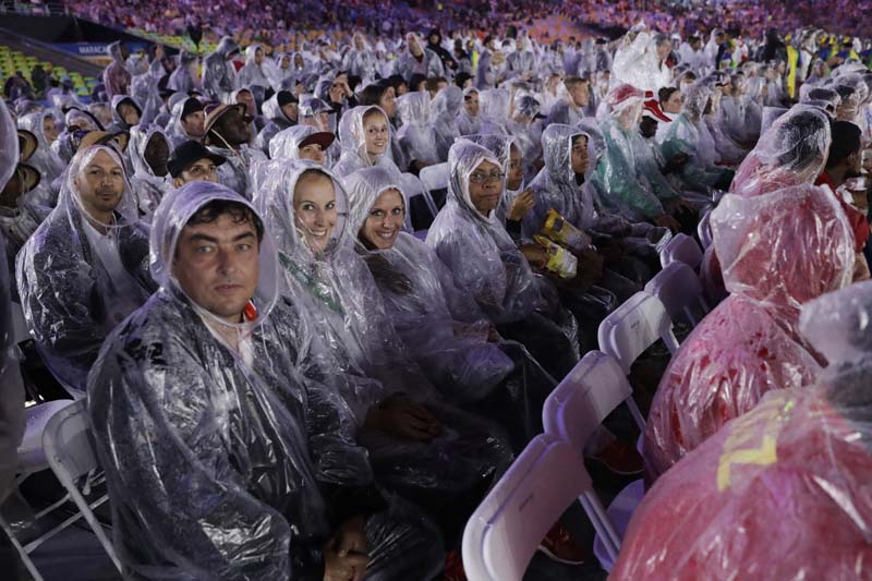 Athletes cover themselves with ponchos during the closing ceremony of the Rio Olympics in the Maracana stadium in Rio de Janeiro, Brazil, on Sunday, August 21, 2016. Photo: AP