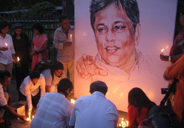 Colleagues and admirers light candles at the grave of Lasantha Wickrematunge in Colombo
