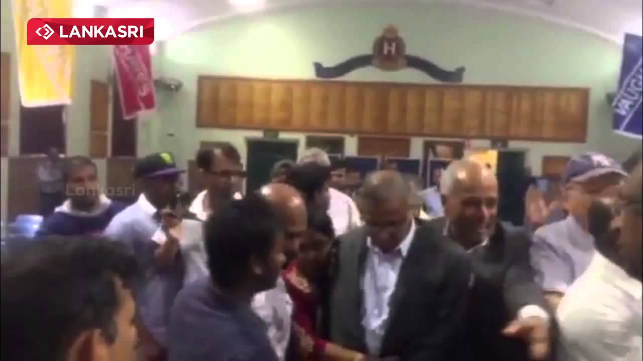 Detained and heckled moderate Tamil MP, M.A.Sumanthiran, being escorted out of meeting hall in Sydney. 