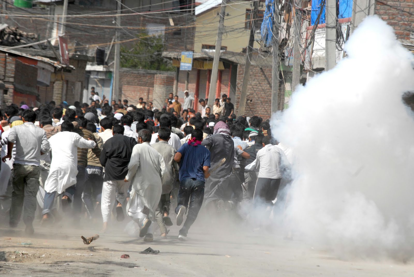 Stone throwing Kashmiri protesters being tear gassed