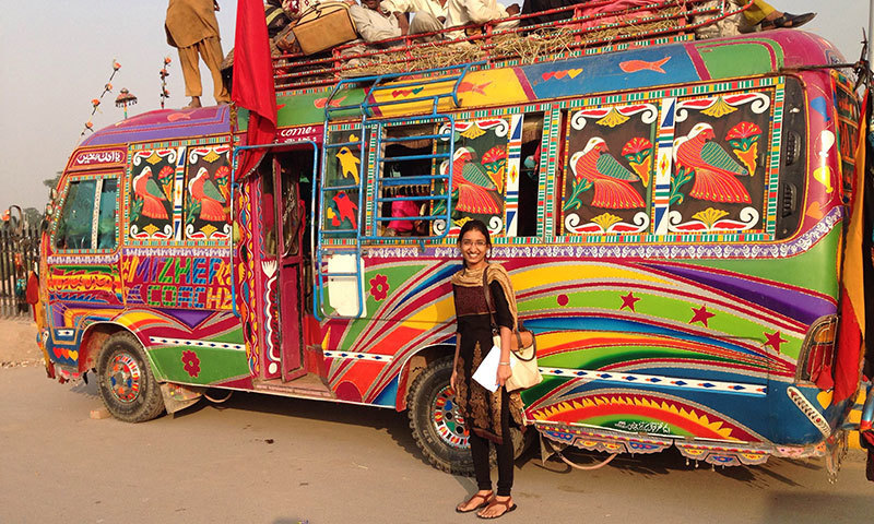 Indian visitor Nikita Singla with a typical Pakistani bus in Lahore