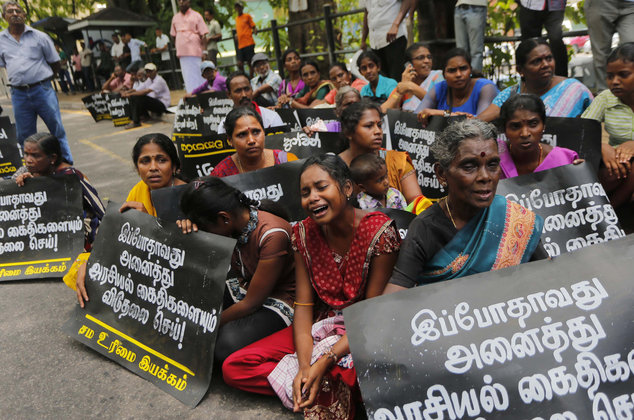 Family members of ethnic Tamil detainees sit for a silent protest in Colombo, Sri Lanka, Wednesday, Oct. 14, 2015. Relatives and civil rights activists are demanding the Sri Lankan government to release hundreds of minority ethnic Tamils detained without charges for years on suspicion of links to the now-defeated Tamil Tiger rebels. Placards read "Release all political prisoners now." (AP Photo/Eranga Jayawardena)