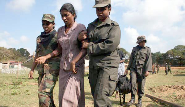 Women soldiers of the Sri Lankan army helping a Tamil refugee get to the army lines at the end of the war