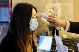 A hotel guest has a temperature measuring device placed on her forehead inside a hotel lobby PHOTO A woman being tested in the Chinese city of Wuhan, where coronavirus originated from.