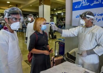 Staff in protective gear screen a passenger at Hamid Karzai International Airport in Kabul on Feb 2, 2020.PHOTO: AFP