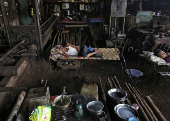 Migrants workers rest inside a workshop after it was shut due to the 21-day nationwide lockdown to slow the spread of the coronavirus disease (COVID-19), in Mumbai, India, April 7, 2020. REUTERS/Prashant Waydande