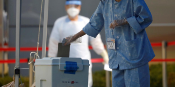 A South Korean patient affected with the coronavirus disease (COVID-19) casts her ballot for the parliamentary election at a polling station set up at a quarantine center in Yongin, South Korea, April 11, 2020. REUTERS/Kim Hong-Ji/File Photo