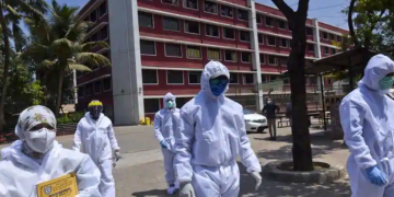 Healthcare workers wearing protective suits and face masks near Dharavi quarantine centres, during a nationwide lockdown imposed as a preventive measure against the Covid-19 in Mumbai, on Tuesday.(Satish Bate/HT Photo)