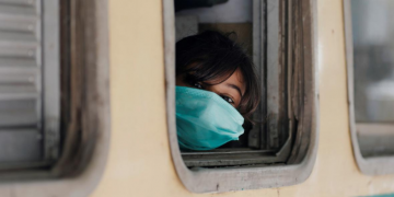 A girl wearing a protective mask looks out from a train window as she returns to her hometown, after Pakistan started easing the lockdown restrictions and allowed to resume passenger trains, following the coronavirus disease (COVID-19) outbreak, in Karachi, Pakistan May 20, 2020. REUTERS/Akhtar Soomro