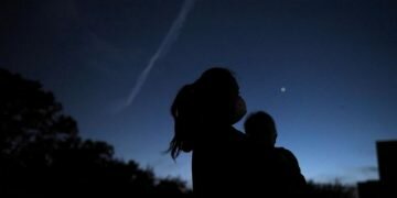 Thao Galvan holds her son Nathan while they view Jupiter and Saturn during a planetary conjuction, as they appear close together in a rare celestial event in Houston, Texas, U.S., December 21, 2020. REUTERS/Callaghan O'Hare