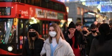 Shoppers walk along Regent Street in the main high-street shopping area of London