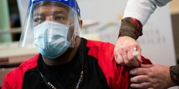 Health care worker Henri Keeling receives his first injection of the fizer-BioNTech vaccine in Martinez, California.PHOTO: NYTIMES