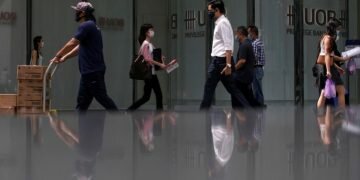 People wearing protective masks as a precaution against COVID-19 walk during lunch hour at the central business district in Singapore,