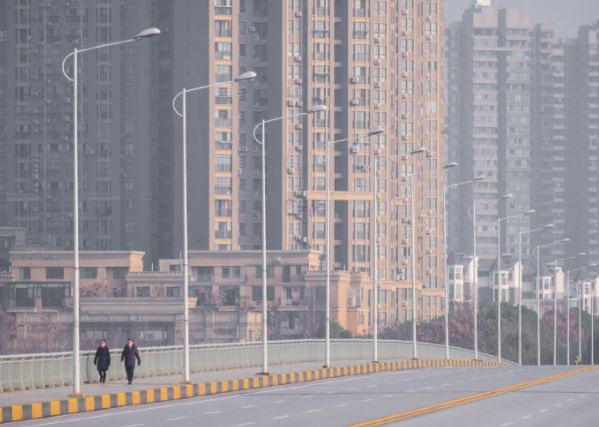 In this Tuesday, Jan. 28, 2020 file photo, people wearing face masks walk down a deserted street in Wuhan in central China's Hubei Province. AREK RATAJ, AP