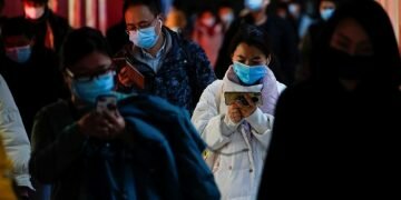 People wearing face masks use their cellphones at a subway station following the coronavirus disease (COVID-19) outbreak, in Shanghai, China January 25, 2021. REUTERS/Aly Song