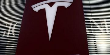 FILE PHOTO: A logo of electric vehicle maker Tesla is seen near a shopping complex in Beijing, China, January 5, 2021. REUTERS/Tingshu Wang/File Photo