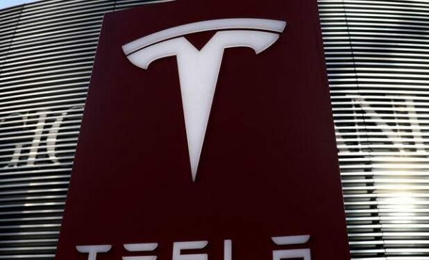FILE PHOTO: A logo of electric vehicle maker Tesla is seen near a shopping complex in Beijing, China, January 5, 2021. REUTERS/Tingshu Wang/File Photo