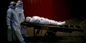 FILE PHOTO: Health workers carry the body of a man who died due to the coronavirus disease (COVID-19) for his cremation at a crematorium in New Delhi, India, June 4, 2020. REUTERS/Adnan Abidi/File Photo