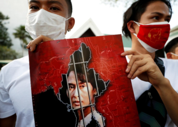 FILE PHOTO: Myanmar citizens hold up a picture of leader Aung San Suu Kyi after the military seized power in a coup in Myanmar, outside United Nations venue in Bangkok, Thailand February 2, 2021. REUTERS/Jorge Silva/File Photo
