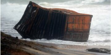 Sri Lankan security personnel remove debris washed ashore from container ship X-Press Pearl