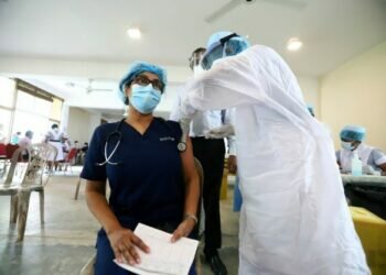 A Sri Lankan health worker gets a third booster shot. Photo: Xinhua/ Ajith Perera