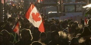 Protesters walk around trucks parked in the downtown area in protest of Covid-19 restrictions in Ottawa. (Photo: AP)