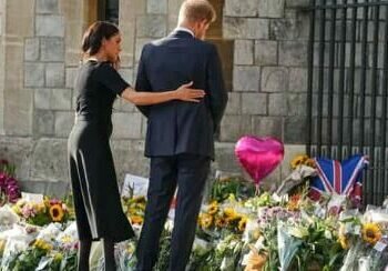 Prince Harry and Meghan, Duchess of Sussex, look at the floral tributes for the late Queen Elizabeth II outside Windsor Castle, in Windsor, England, Sept. 10, 2022. (AP Photo/Martin Meissner) (AP)