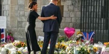 Prince Harry and Meghan, Duchess of Sussex, look at the floral tributes for the late Queen Elizabeth II outside Windsor Castle, in Windsor, England, Sept. 10, 2022. (AP Photo/Martin Meissner) (AP)
