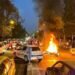 A police motorcycle burns during a protest over the death of Mahsa Amini. (Image: Reuters)