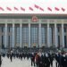 People walk in front of the Great Hall of the People on March 4, 2023, in Beijing, as the annual gathering known as the Two Sessions gets underway.