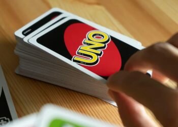 A person is seen playing UNO card game.