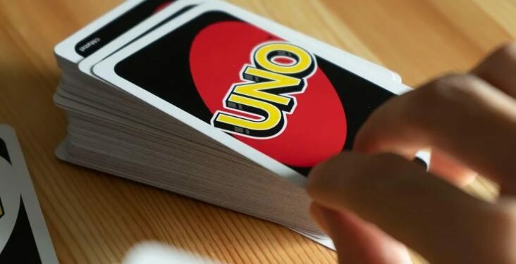 A person is seen playing UNO card game.